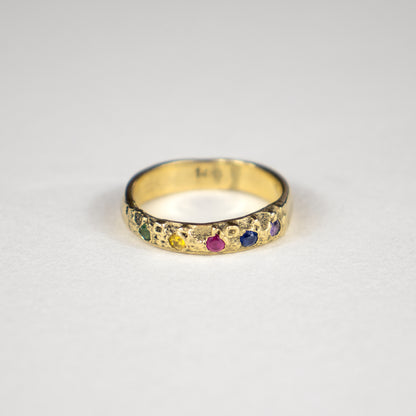 Solid reclaimed 14k gold Vomer ring with 4mm band-width set with five 2 mm rainbow green, yellow, pink, blue and purple sapphires.