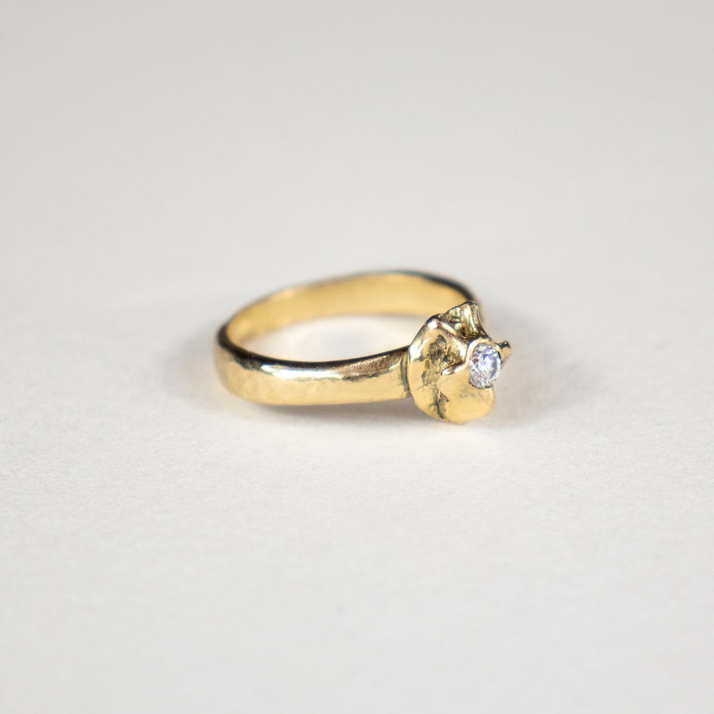 Solid reclaimed 14k gold vertebrae plague ring with 2.5 mm band-width set with a 3 mm diamond.