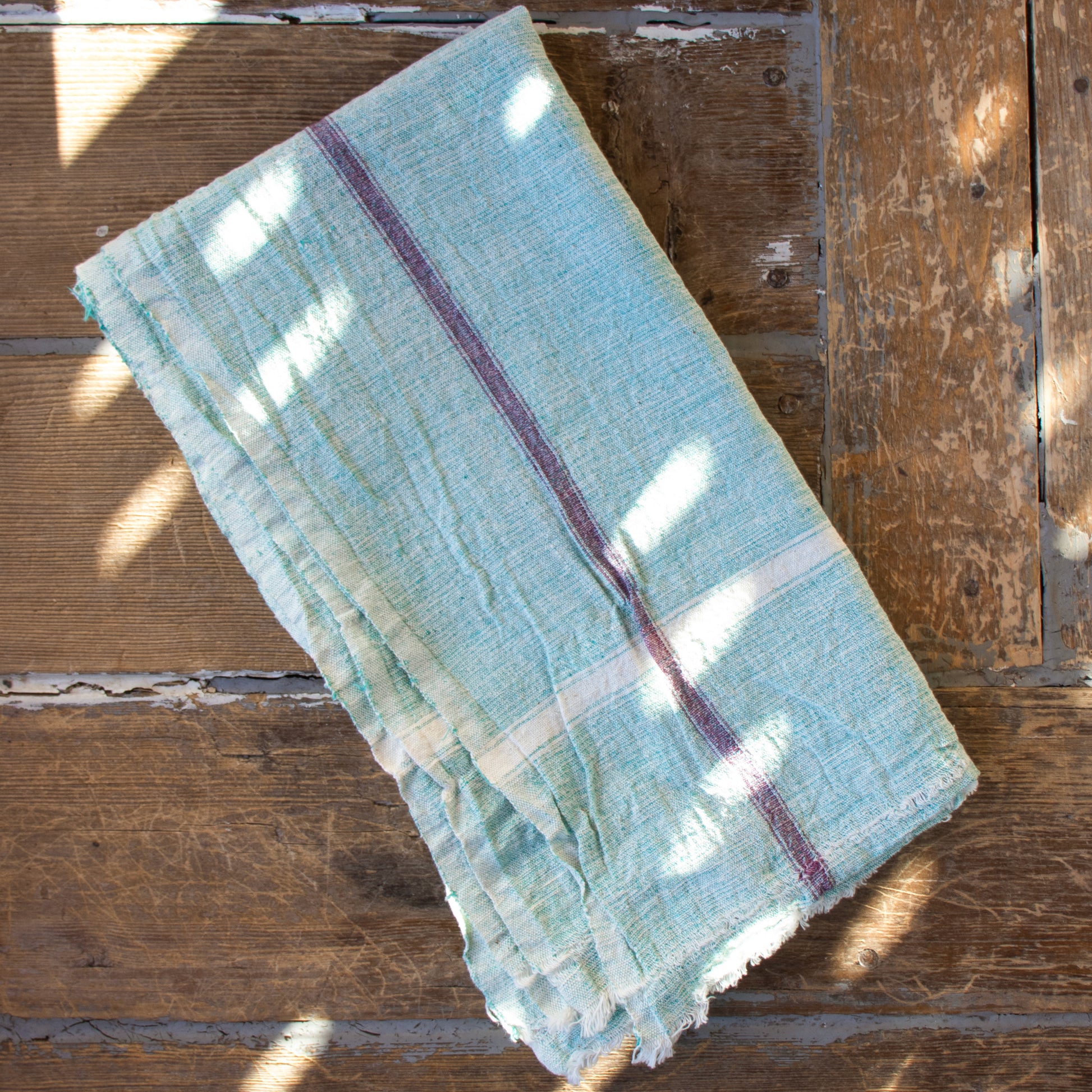 Indian 100% cotton khadi towels—a fabric woven by hand of hand-spun yarn available in your choice of pale blue or green with color pinstripe accents shown and measuring 31 x 56 inches overall.