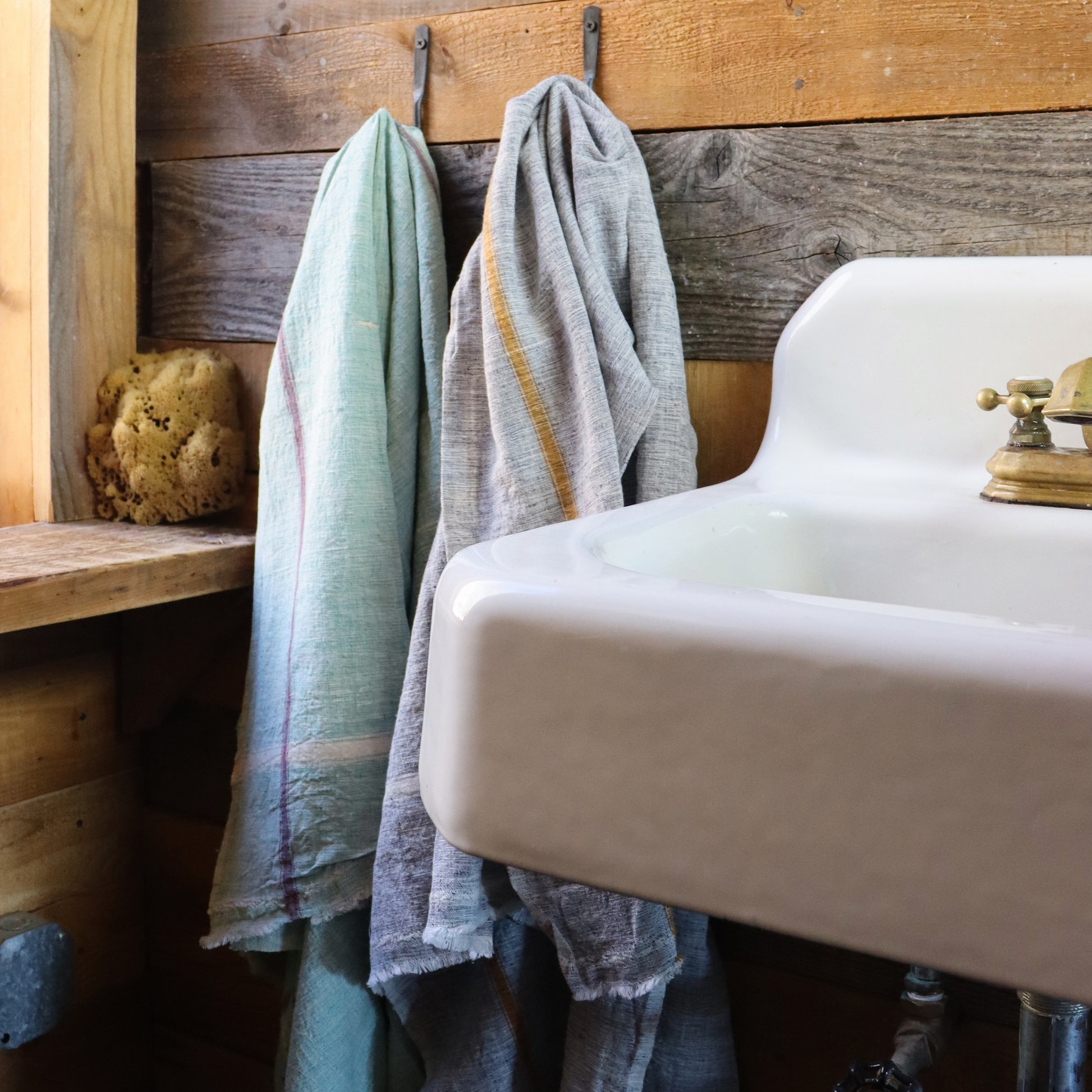 Indian 100% cotton khadi towels—a fabric woven by hand of hand-spun yarn available in your choice of pale blue or green with color pinstripe accents shown and measuring 31 x 56 inches overall shown in rustic Catskills home.