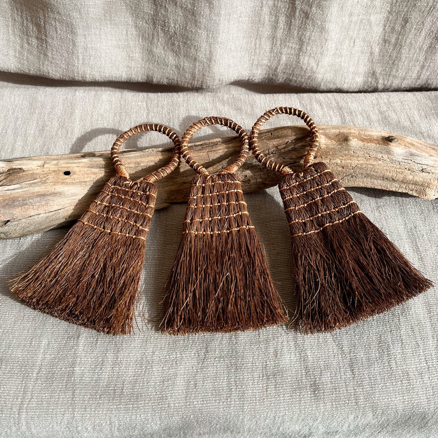 Handmade hand brush made with sustainably sourced palm fibers measuring 5 inches in length and 3 inches in width.