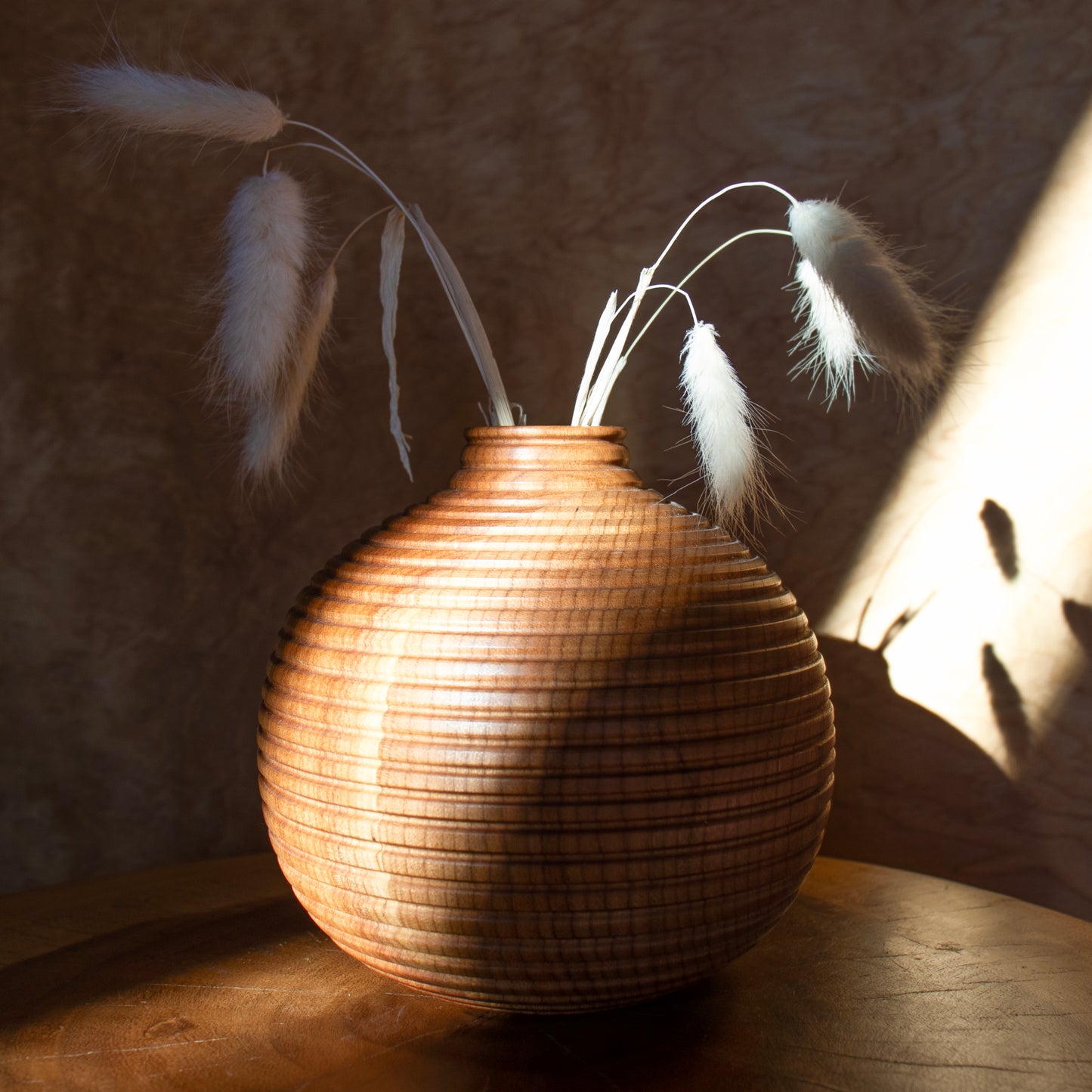 Hand-turned cherry vase from Han Studio in Pittsburgh is turned on the lathe, hand-carved with a small chisel to create the detailed texture, and finished with an eco-friendly matte oil. This is a solid piece for dried flowers only and is not watertight and measures 5.5 x 5.5 inches.