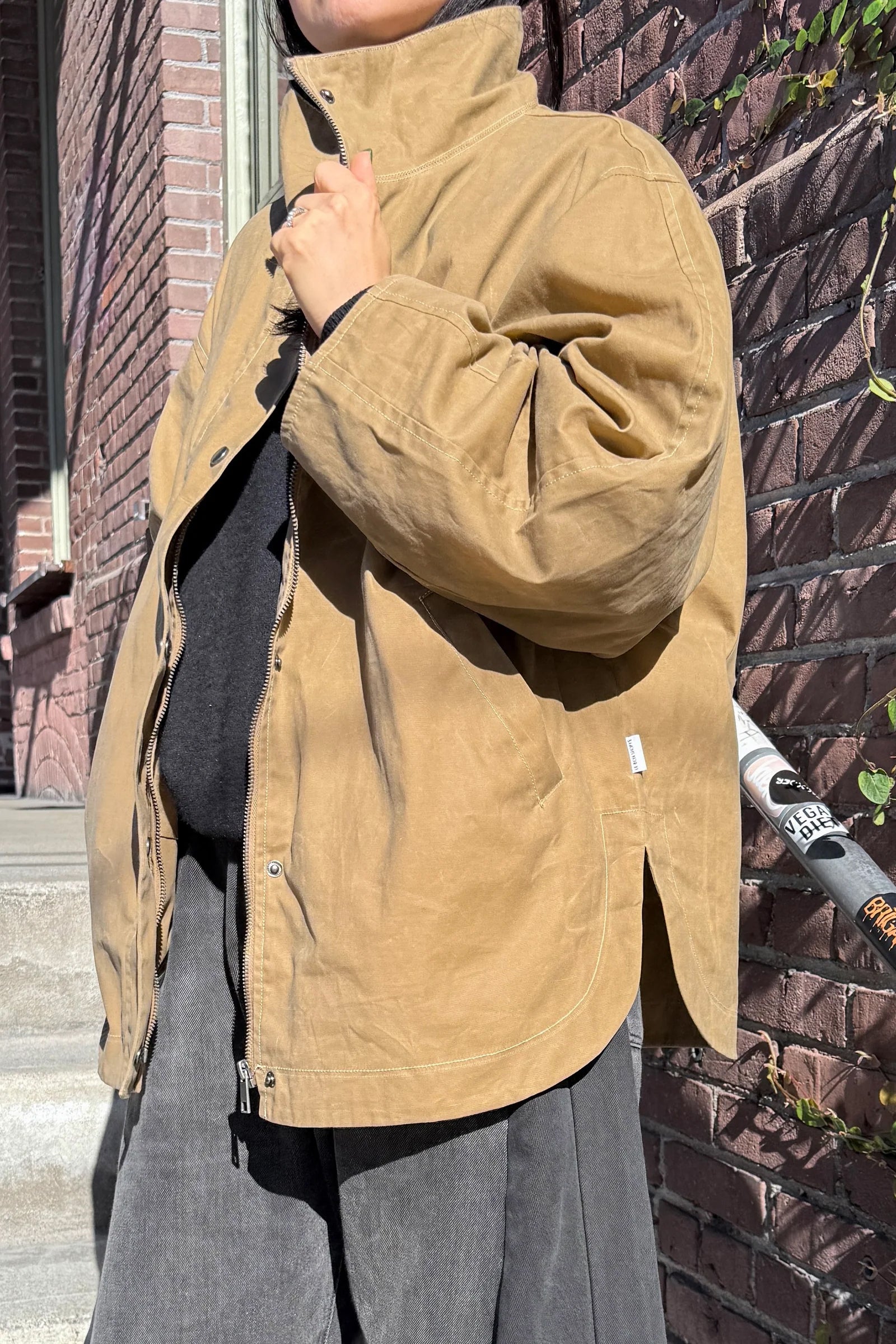 Rain or shine, the Blair fits any wardrobe with a modern silhouette featuring a high funnel neck, roomy barrel sleeves, and a secure zip-and-button front made from durable waxed cotton built to take on light, wet weather.